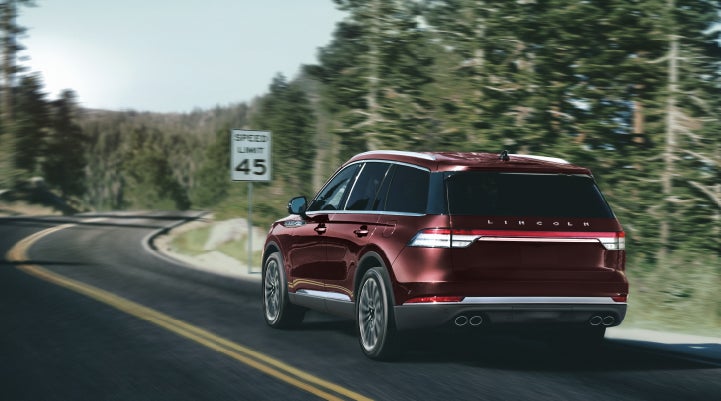 A 2024 Lincoln Aviator® SUV is being driven on a winding mountain road | Libertyville Lincoln Sales, Inc. in Libertyville IL